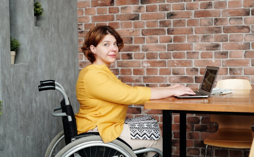 woman in wheelchair typing on laptop