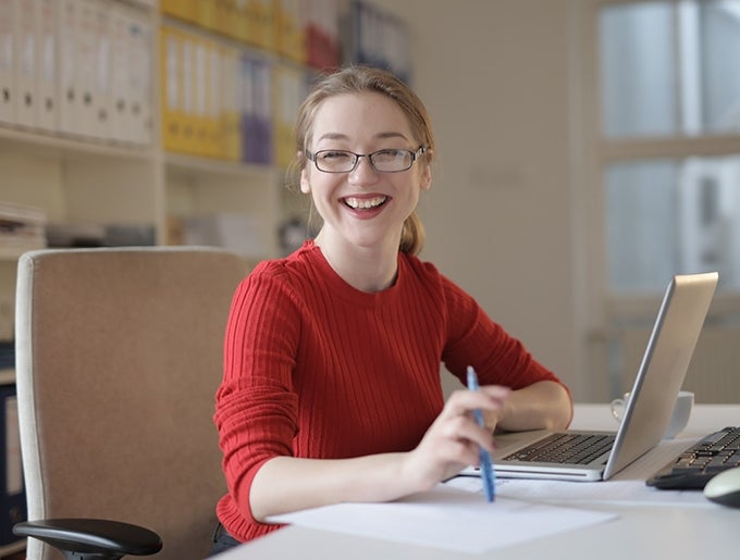 Girl at computer smiling at us