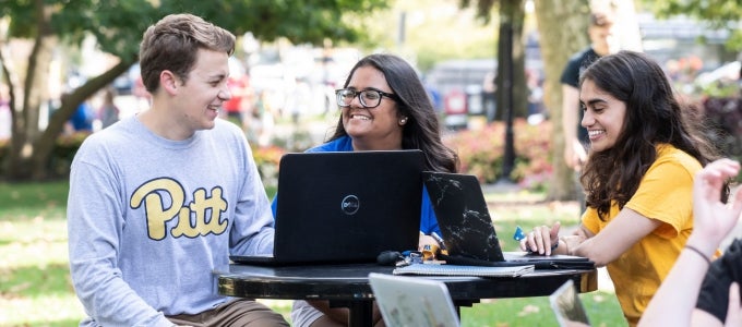 Students laughing around computer