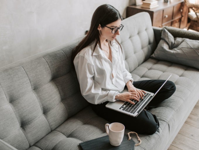 Student working on laptop on couch. 