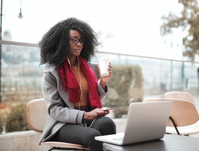 woman with headphones drinking coffee