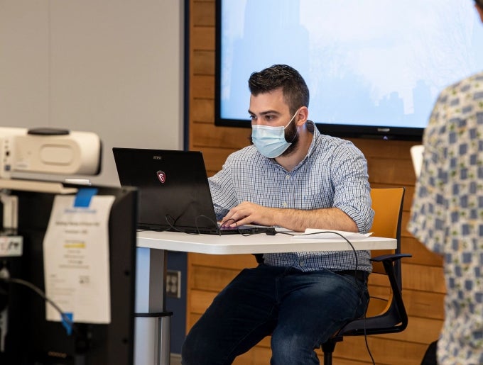 Pitt staff working while wearing facemask.