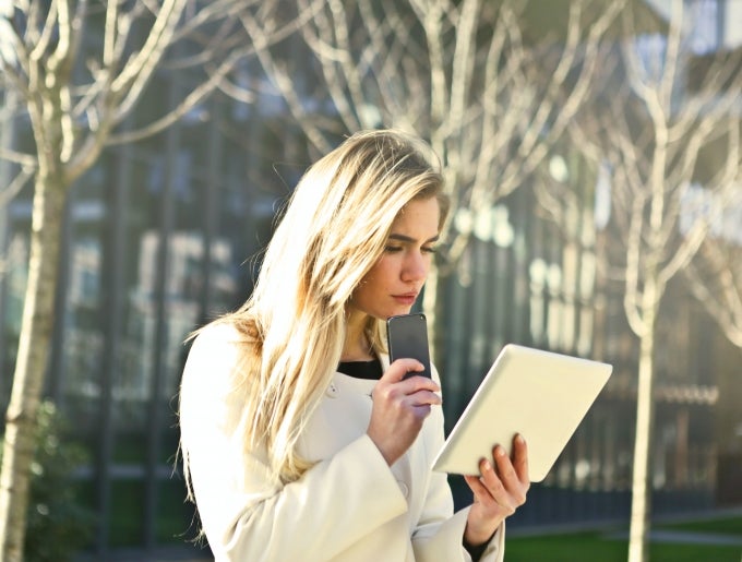 woman using phone and tablet