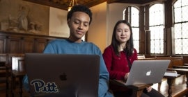 Two students with laptops in Nationality Room